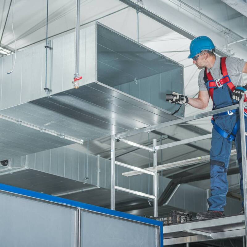 HVAC Technician Testing Newly Installed Warehouse Ventilation System